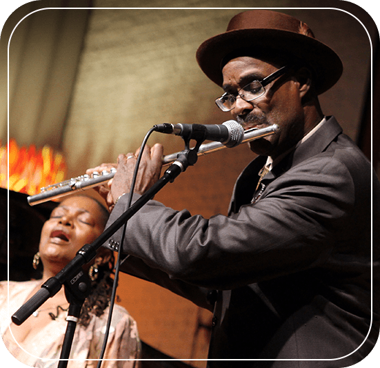 A man and woman singing on stage with microphones.