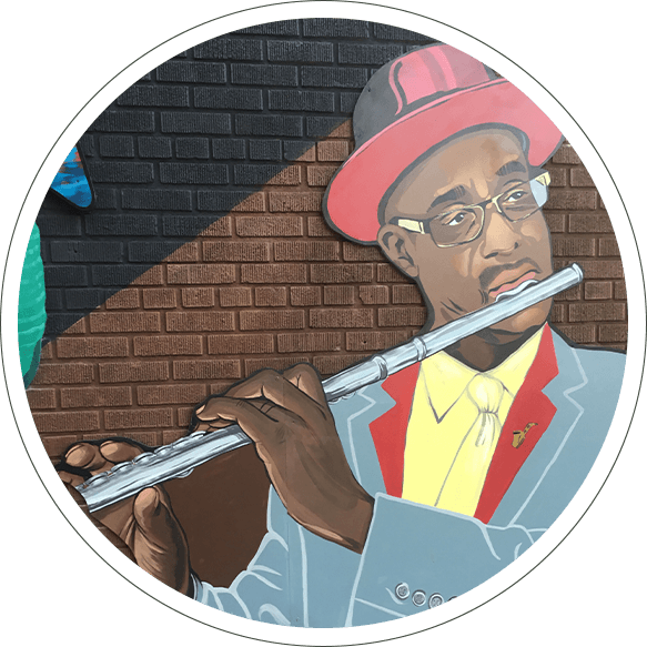 A man with a red hat is playing the flute