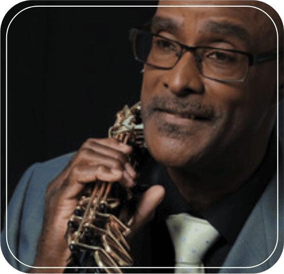 A man holding his neck tie while wearing glasses.